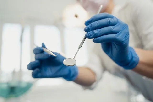 Profissional de Odontologia segurando equipamentos durante atividade